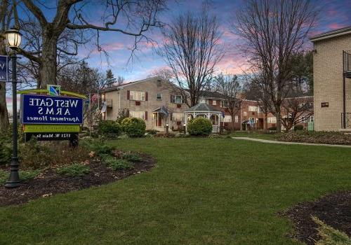 Evening view of the West Gate Arms apartment community in Jeffersonville, with warm lights illuminating the courtyard