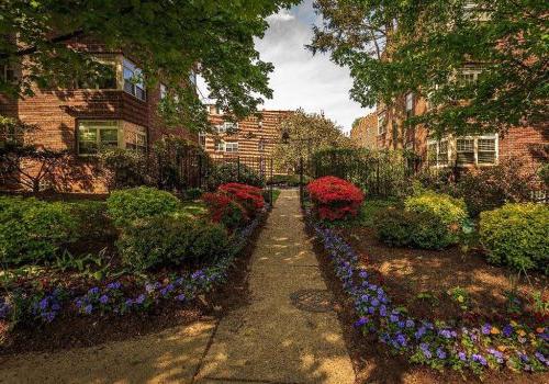 Beautifully landscaped entrance surrounded by flowers at 塞奇威克花园 apartments for rent